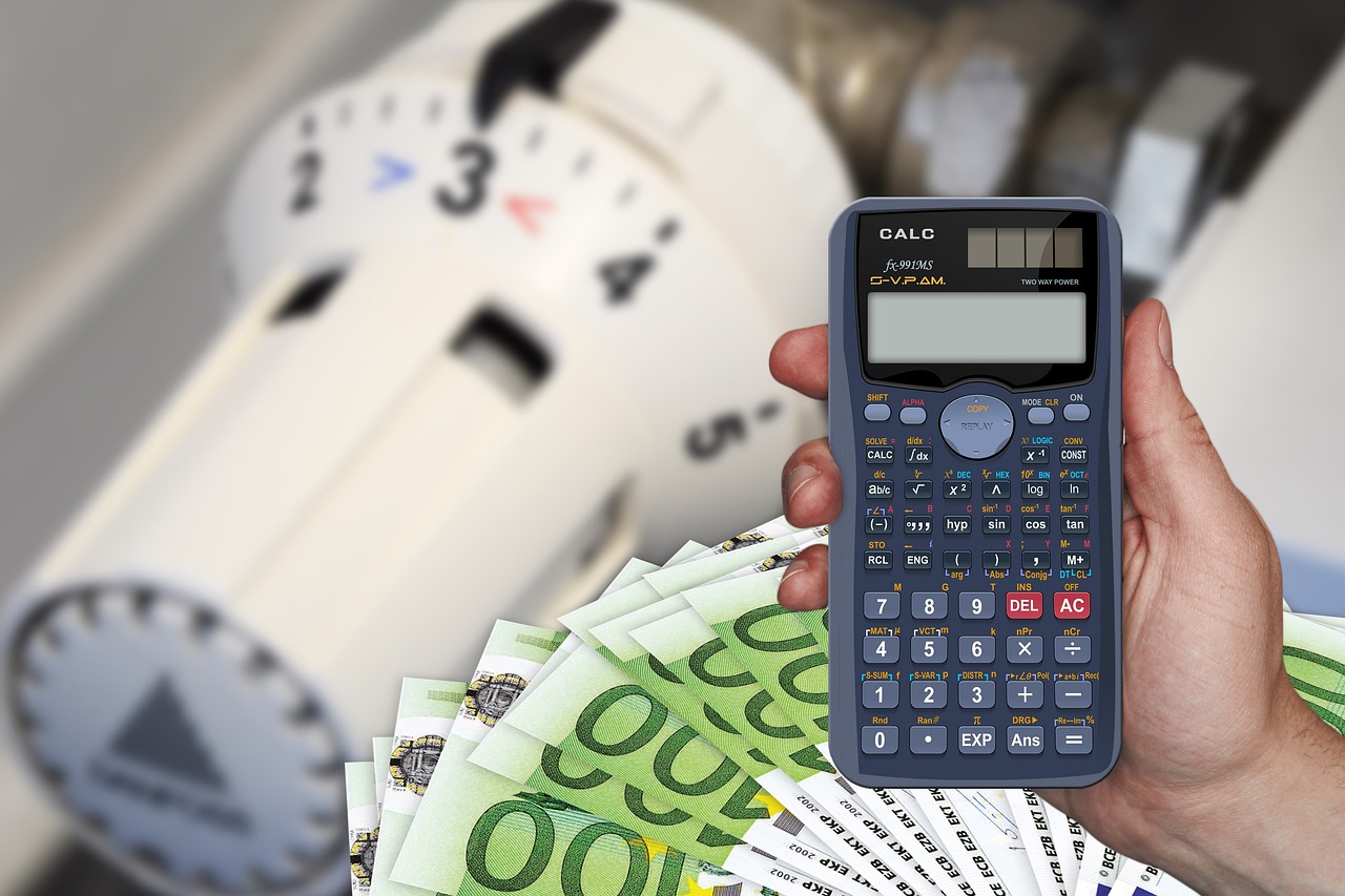 Taschenrechner vor einer Heizung - Energie-Kosten sparen mit Energie-Management